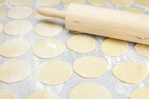 Round shape of the dough and rolling pin with flour on the table — Stock Photo, Image
