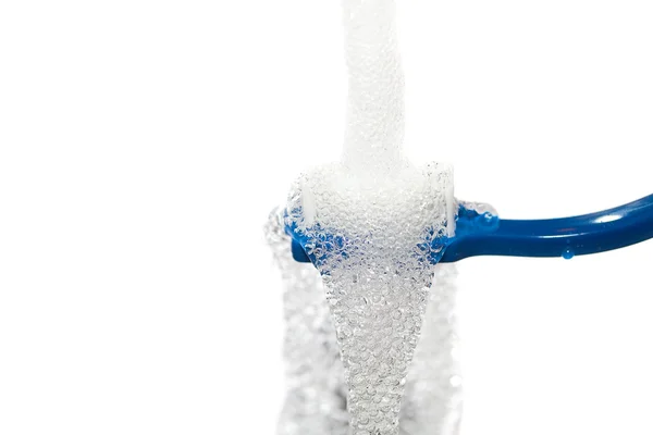 Blå tandborste under rinnande vatten — Stockfoto