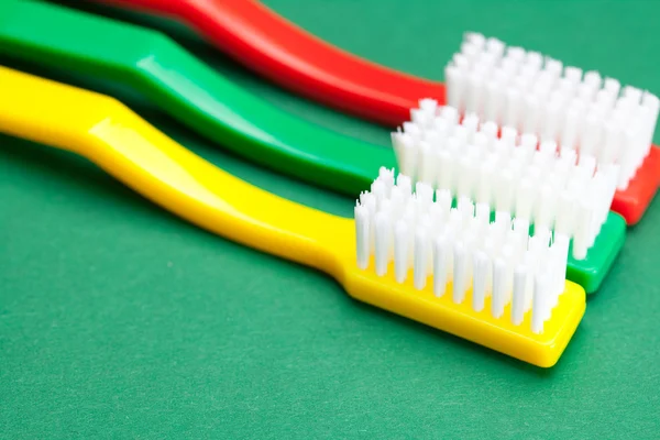 Cepillo de dientes de color sobre un fondo verde — Foto de Stock