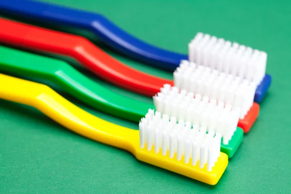 Cepillo de dientes de color sobre un fondo verde — Foto de Stock