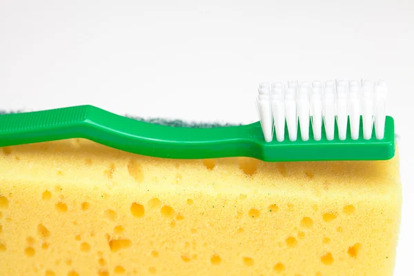 Szivacs a mosogatás és elszigetelt fehér fogkefe — Stock Fotó