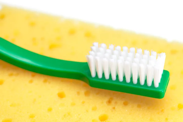 Szivacs a mosogatás és elszigetelt fehér fogkefe — Stock Fotó