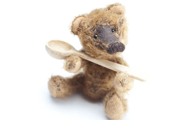 Teddy Bear and a wooden spoon isolated on white — Stock Photo, Image