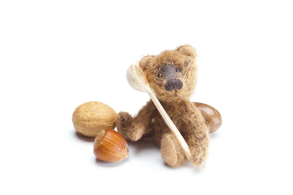 Nallebjörn, nötter och trä sked isolerad på vit — Stockfoto