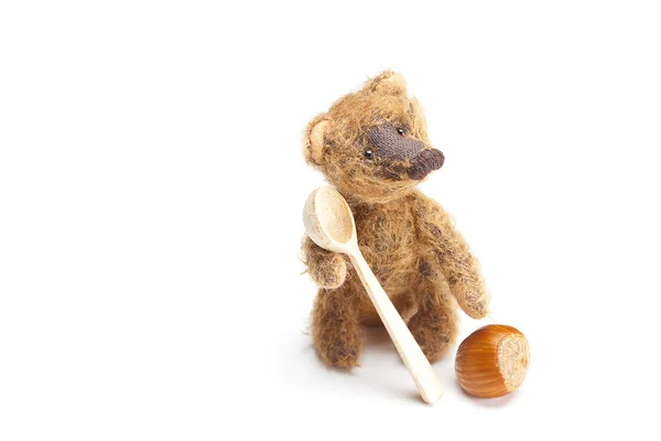 Urso de pelúcia, nozes e colher de madeira isolada em branco — Fotografia de Stock