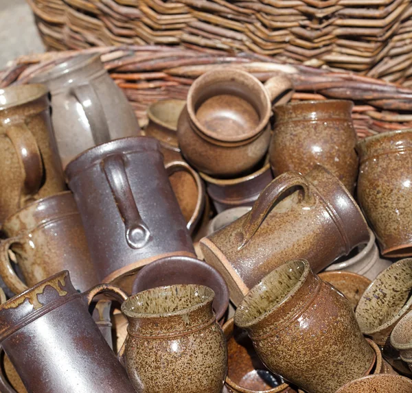 Jarros de cerâmica e copos em uma cesta na feira — Fotografia de Stock