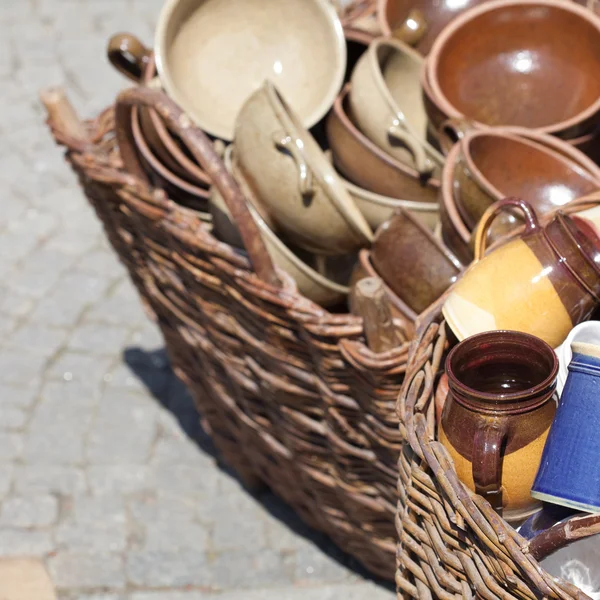 Ceramic jugs and cups in a basket at the fair — Stock Photo, Image