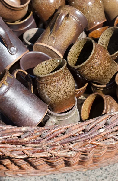 Ceramic jugs and cups in a basket at the fair — Stock Photo, Image