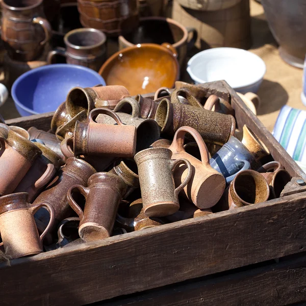 Jarras y tazas de cerámica en una cesta en la feria — Foto de Stock