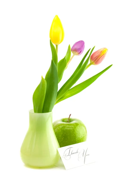 Coloridos tulipanes en jarrón, manzana y una tarjeta firmada gracias isolat —  Fotos de Stock
