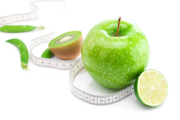 Яблоко, лайм, горох, киви и измерительная лента изолированы на белом — стоковое фото