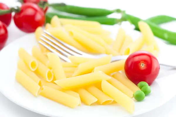 stock image Tomatoes, peas, pasta and fork on a plate isolated on white