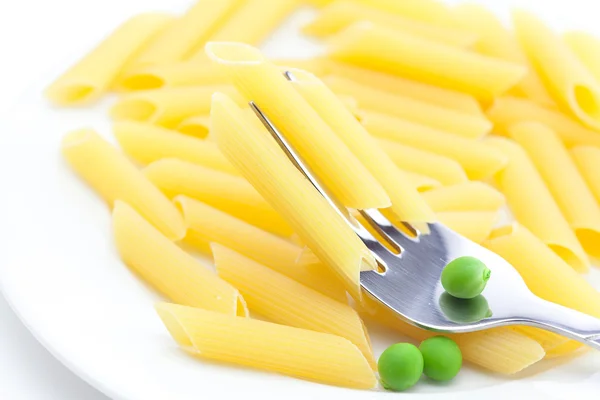 Guisantes, pasta y tenedor en un plato aislado sobre blanco —  Fotos de Stock