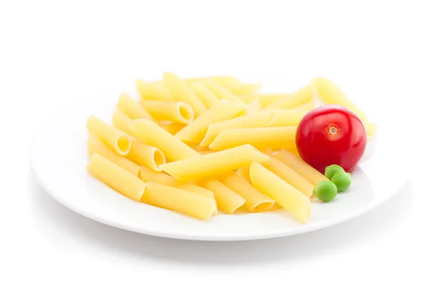 Помидор, горох и макароны на тарелке изолированы на белом — стоковое фото