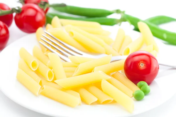 Tomatoes, peas, pasta and fork on a plate isolated on white — Stock Photo, Image