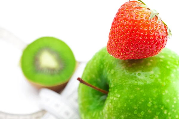 Jordgubbar, äpple med vatten droppar, kiwi och mått band isolat — Stockfoto