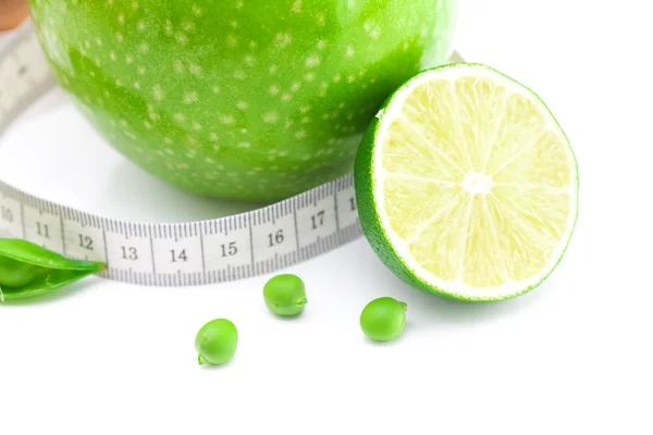 Apple,lime,peas and measure tape isolated on white — Stock Photo, Image
