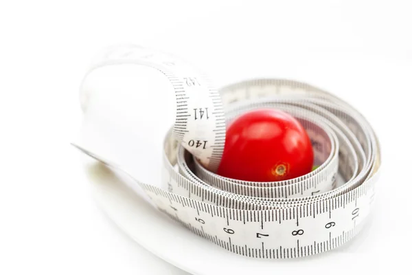 白で隔離される皿にトマトと測定テープ — ストック写真