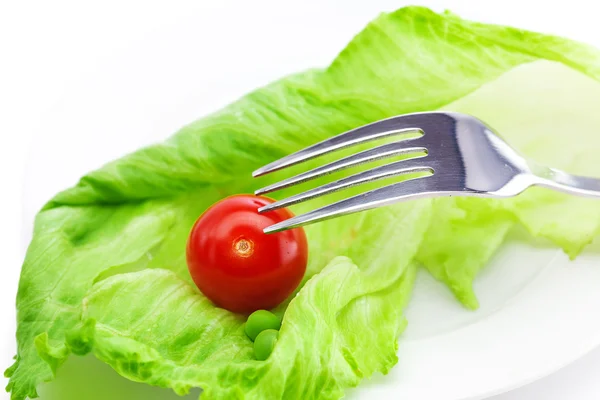 Roșii și salată verde cu o furculiță pe o farfurie izolată pe alb — Fotografie, imagine de stoc