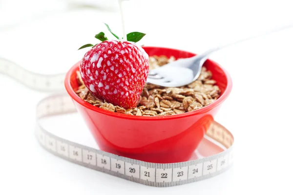 stock image Strawberry,milk,fork,measure tape and wheat in a bowl isolated o