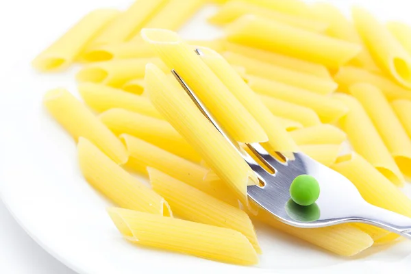 Hrách, těstoviny a vidličkou na talíři izolované na bílém — Stock fotografie