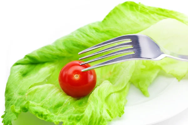 Tomato and lettuce with a fork on a plate isolated on white — Stock Photo, Image