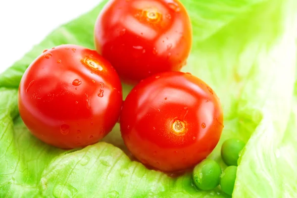 Tomaten, Erbsen und Salat auf einem Teller isoliert auf weiß — Stockfoto