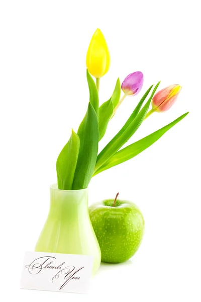 Barevné tulipány váza, jablko a kartu podepsanou isolat Děkuji — Stock fotografie