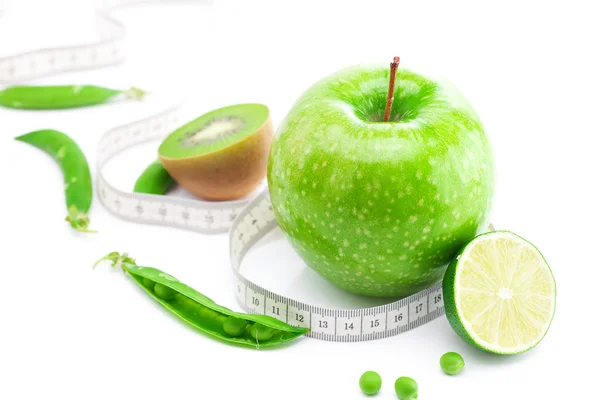 Jablko, vápno, hrášek, kiwi a měr páska izolované na bílém — Stock fotografie