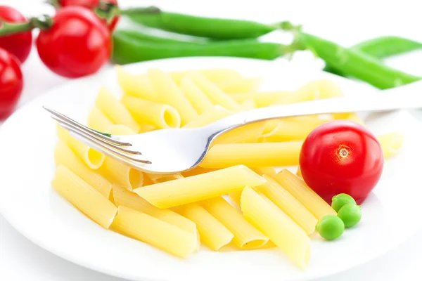 stock image Tomatoes, peas, pasta and fork on a plate isolated on white