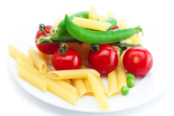 Tomates, guisantes, pasta en un plato aislado en blanco —  Fotos de Stock