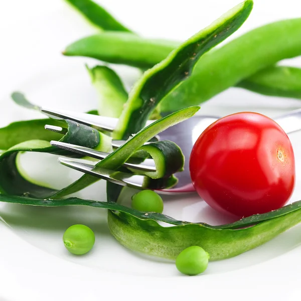 Tomat, gaffel, gurka hud, ärtor och mäta tejp på en tallrik isol — Stockfoto