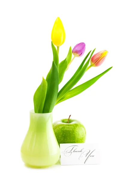 Colorful tulips in vase,apple and a card signed thank you isolat — Stock Photo, Image