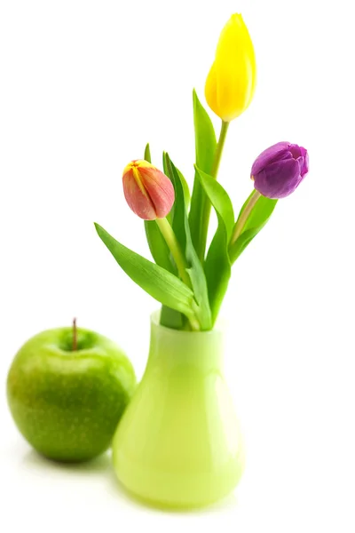 Colorful tulips in vase and apple isolated on white — Stock Photo, Image