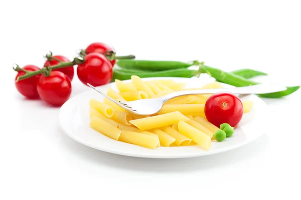 Pomidory, groch, makaron i widelec na płytce na białym tle — Zdjęcie stockowe