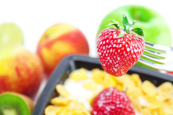 Jordgubbar, persika, äpple, kiwi, gaffel, mjölk och flingor i en skål — Stockfoto