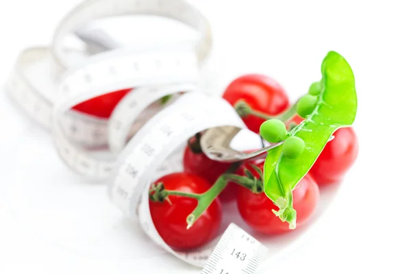 Tomate, garfo, ervilhas e fita métrica em uma placa isolada em branco — Fotografia de Stock