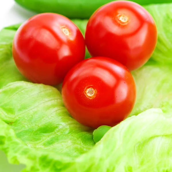 Tomate, ervilhas e alface sobre um prato isolado sobre branco — Fotografia de Stock