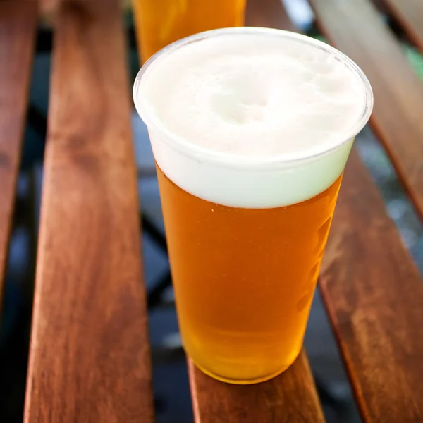 Copo de cerveja em pé sobre uma mesa de madeira — Fotografia de Stock