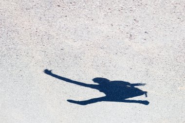 asfalt üzerinde atlama bir adamın gölgesi