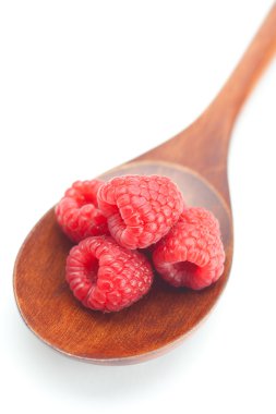 Wooden spoon and raspberries isolated on white clipart