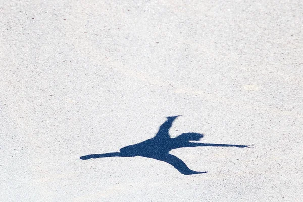 Asfalt üzerinde atlama bir adamın gölgesi — Stok fotoğraf