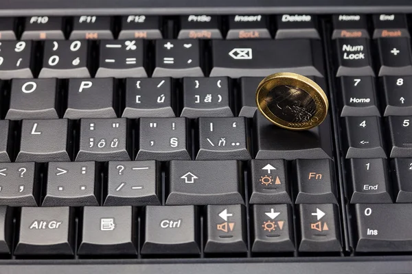 Laptop keyboard and coin euro — Stock Photo, Image
