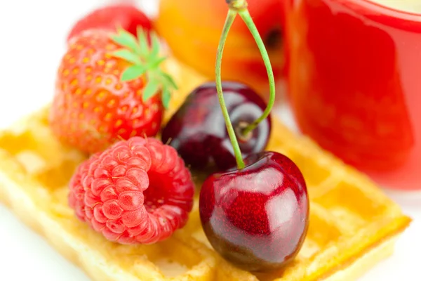 Cappuccino cup, waffles, cherries, strawberries and raspberries — Stock Photo, Image