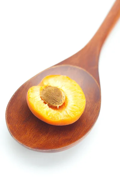 Wooden spoon and apricots isolated on white — Stock Photo, Image