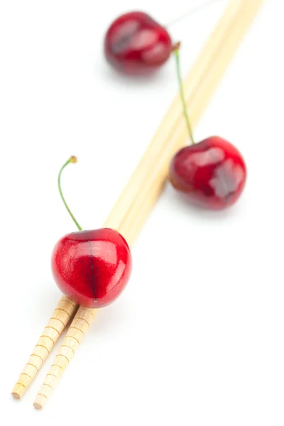 Cherry and chopsticks isolated on white — Stock Photo, Image