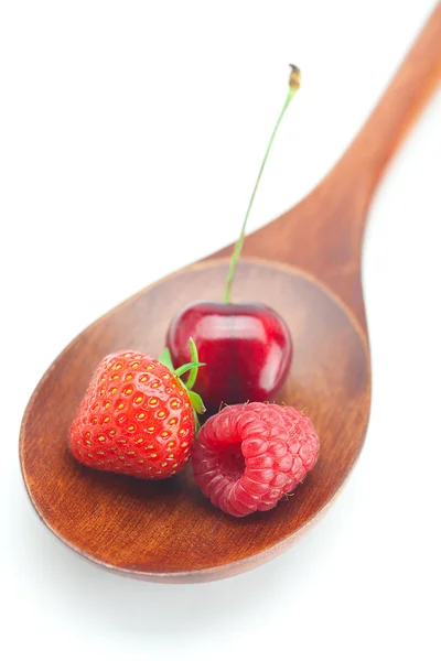 Wooden spoon,raspberry, cherries and strawberry isolated on whi — Stock Photo, Image