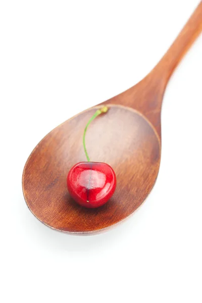 Wooden spoon and cherry isolated on white — Stock Photo, Image