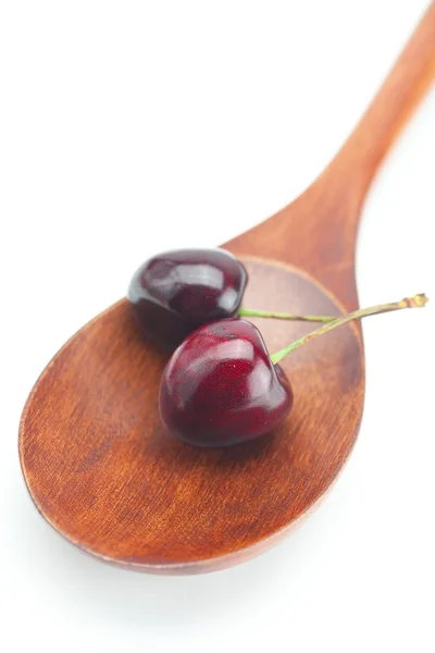 Wooden spoon and cherry isolated on white — Stock Photo, Image