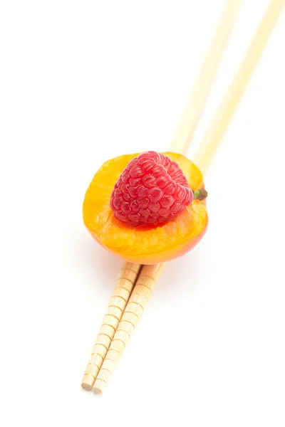 Raspberry, apricot and chopsticks isolated on white — Stock Photo, Image